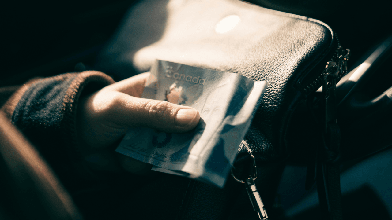 Canadian Holding a 5 dollar bill